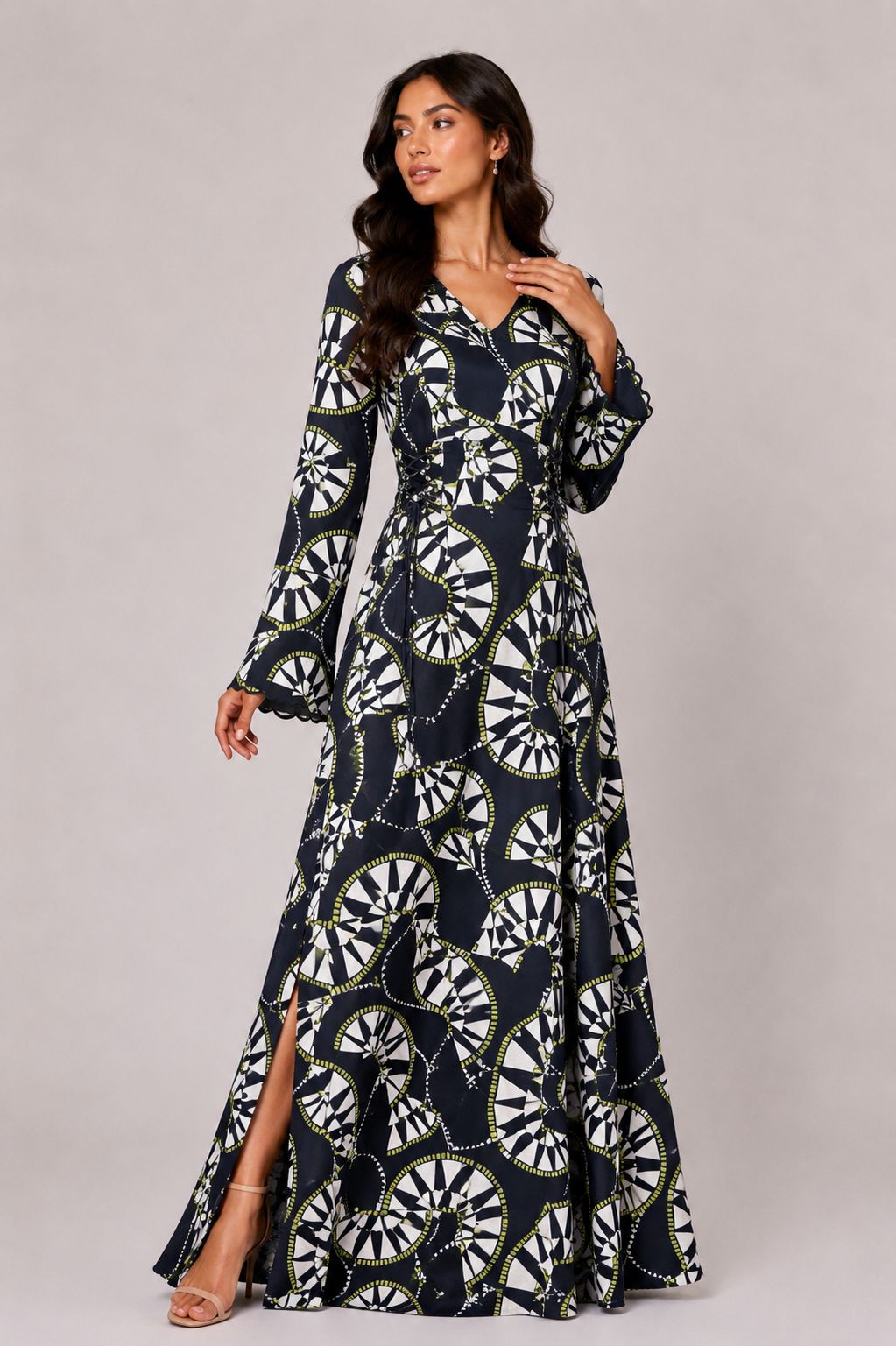 Woman wearing a long, patterned dress against a plain background