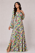 Woman wearing a colorful patterned dress on a plain background