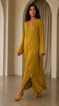 Muse — Mustard dress with decorative V-neckline, walking view.