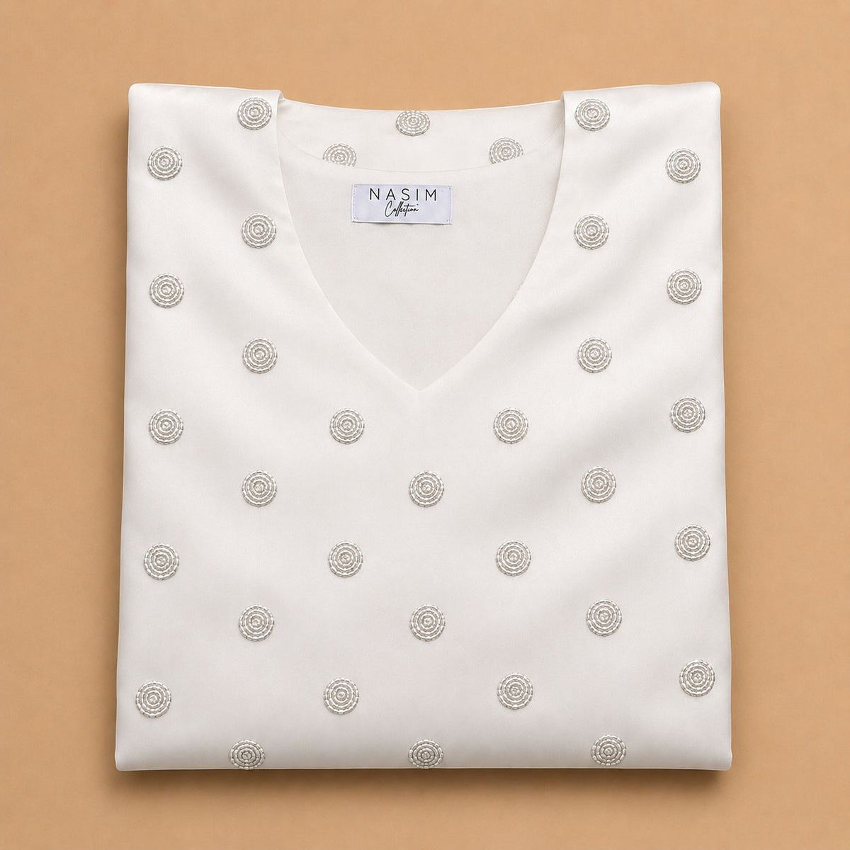 NC#MK13 — Folded white Mkhawar with silver-tone circular motifs.