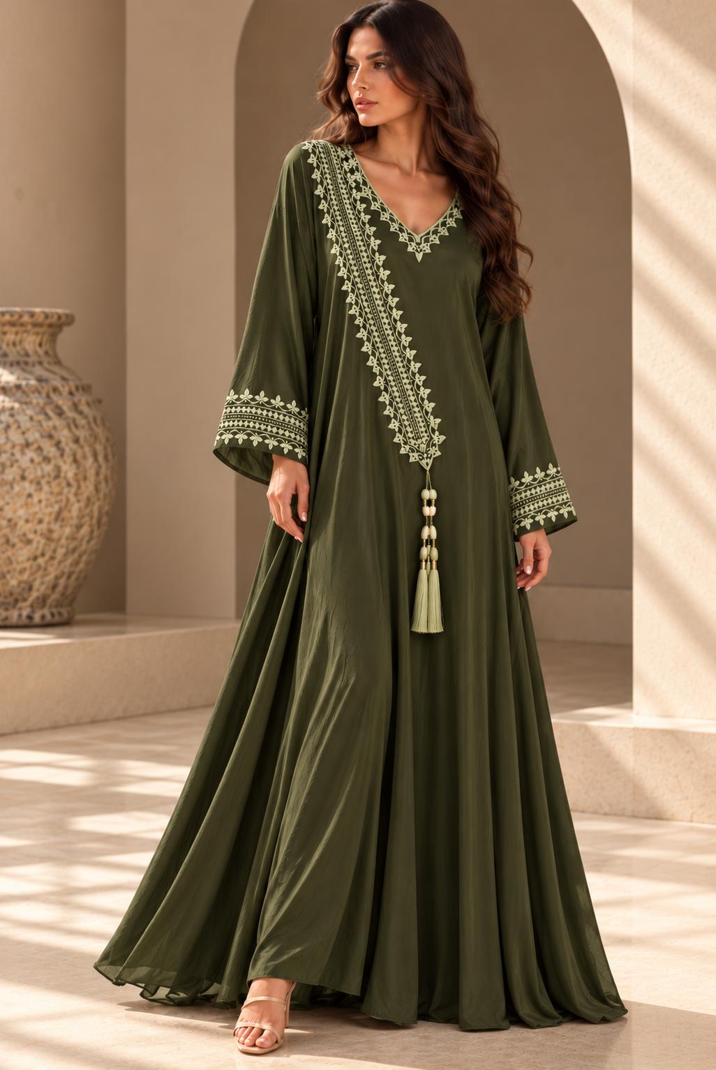 Olive Green full-length cotton dress with pale green hand embroidery, a V-neck, diagonal embroidered panel, long sleeves and tassel.