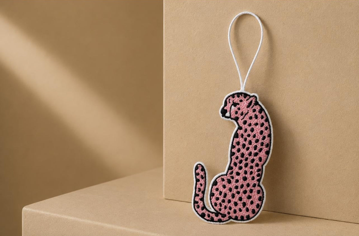 Pink Cheetah Charm — Pink spotted cheetah-shaped charm with white loop.