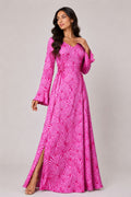 Woman wearing a pink patterned dress on a plain background
