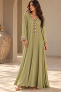 Sage-green full-length soft linen dress with long sleeves and contrasting decorative trim at the neckline, front and cuffs.